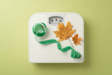 Autumn health goals. Top-view image with scales, tape measure and maple leaves on light green background. Adaptable area for text or promotional content