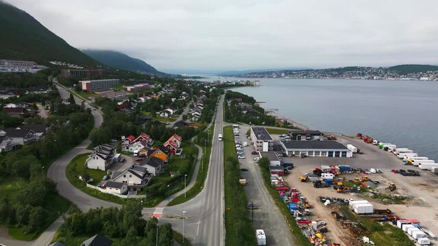 Aerial tracking shot of bus on road next to fjord in Tromso, Norway