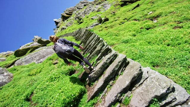 Stairs with woman walking up them on sunny day in Ireland. Skellig Michael