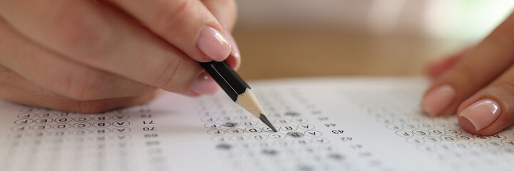 Woman solving tests and writing with pencil on paper - obrazy, fototapety, plakaty