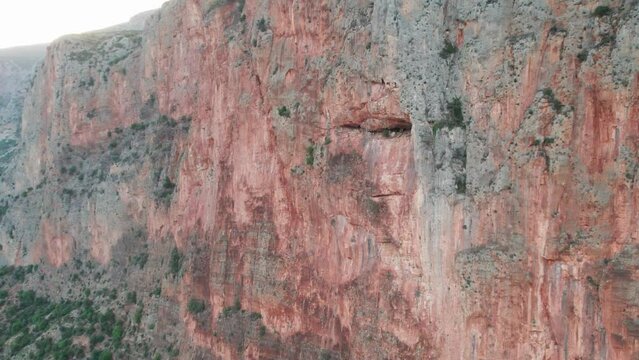 Drone parallax pullback around sheer huge wall of rock climbing paradise, leonidio greece
