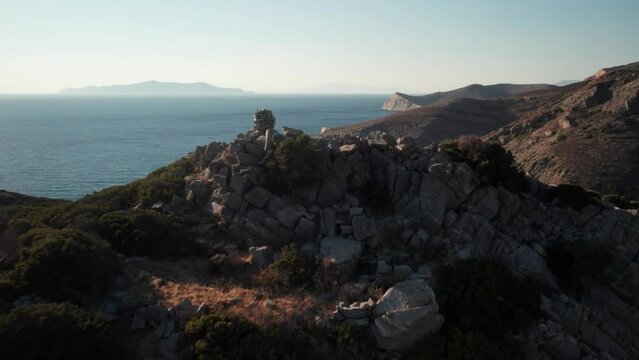 Drone rises above cairn at summit to reveal stunning vast ocean expanse from syros greece island