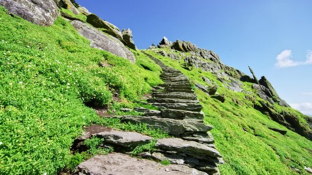 Green grass stairway leading up mountain peak.  Ancient stairway Skellig Michael