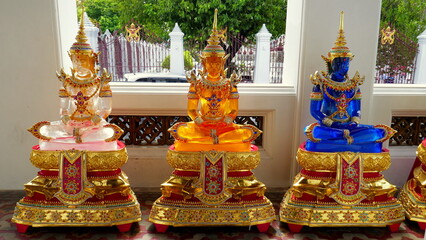 3 gläserne bunte Buddha Statuen stehen vor einem Tempel beim Wat Arun