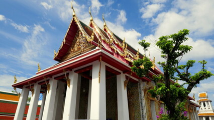 Fototapeta premium herrlicher buddhistischer Tempel beim Wat Arun in Bangkok umgeben von dekorativen grünen Bäumen