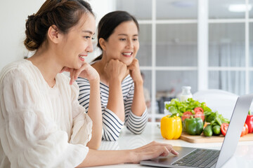 Asian women prepare ingredients for cooking follow cooking class online course on website via tablet. cooking content on internet technology for modern lifestyle concept