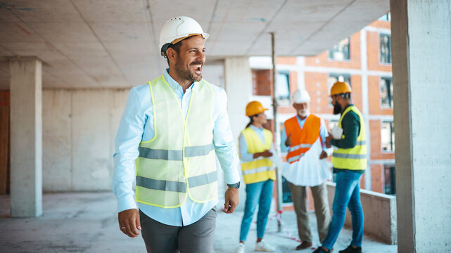 Male construction engineer working on building site. Construction Worker Planning Constractor Developer Concept. Successful contractor at building site with copy space..