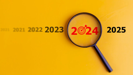 Target of business concept. magnifier focusing on the year 2024. Focus on new business goals,...
