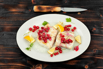Fried cod fillet with berries, fish dish.
