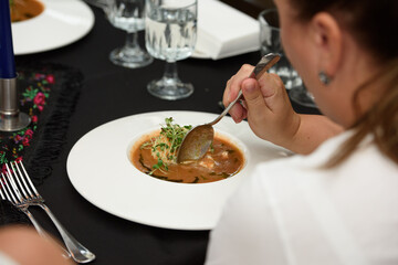 woman in a restaurant eat tomato gazpacho soup. Tasty appetizing summer tomato soup.