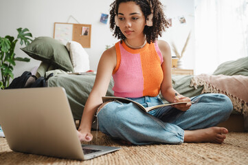 Girl using laptop and doing homework at home