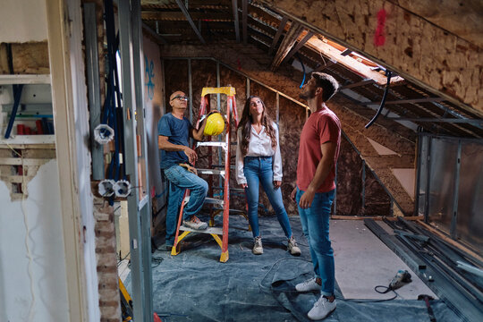Man and woman having discussion with construction worker at construction site
