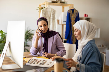 Wedding planner with colleague talking on smart phone
