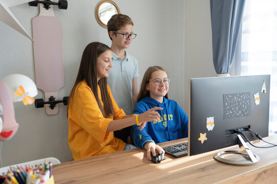 Smiling girl playing video game on computer by friends at home