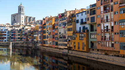 Fototapeta na wymiar Pintoresque and colourfoul houses by the river with the church in the back in Girona