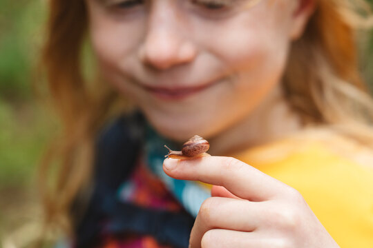 Girl with small snail on finger