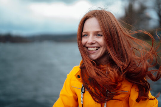 Happy redhead woman wearing yellow jacket