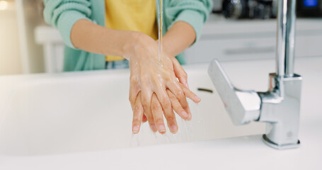 Fototapeta premium Washing hands, woman cleanse and kitchen sink of a female with soap for cleaning and wellness. Home, safety and virus protection of a person with healthcare in a house for skincare and grooming