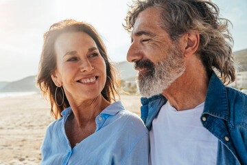 Happy senior couple at beach on sunny day