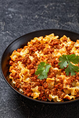 Lasagnette bolognese in black bowl, top view