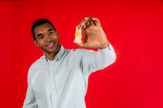 Man showing eaten apple against red background