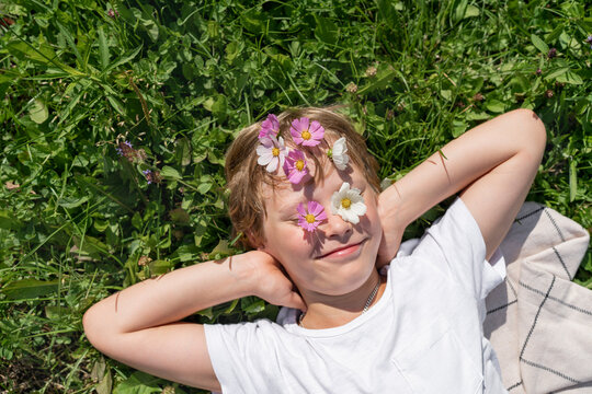 Happy boy with flowers on forehead and eyes on sunny day