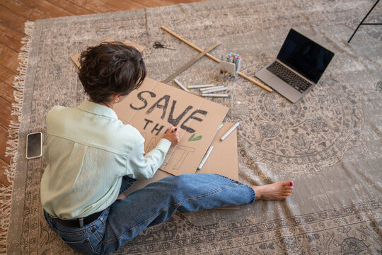 Activist making environment placard in living room