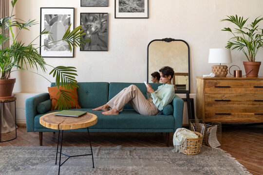 Woman using smart phone on sofa at home