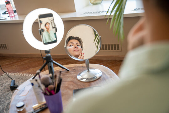 Reflection of smiling influencer in mirror wearing eye patch