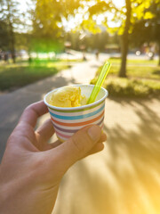 Man is eating tasty ice-cream in the street. Perfect cold summer dessert. Summer sweet sunset. Vertical photo.