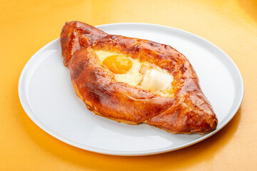 Adjar-style khachapuri with cheese, egg and butter. Caucasian cuisine. Isolated image on a gray background.
