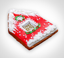 New Year's gingerbread in the shape of a house. A festive treat. Isolated on a white background.