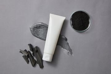 A tube without label is decorated with a smear of clay mask and a petri dish of activated charcoal...
