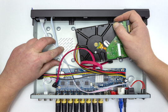 a technician or engineer installs a hard disk into a video surveillance system, cctv, top view