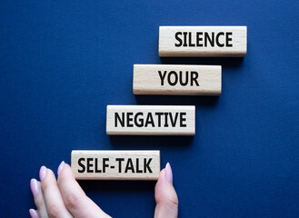 Silence your negative self-talk symbol. Concept words Silence your negative self-talk on wooden blocks. Doctor hand. Beautiful deep blue background. Psychology concept. Copy space.