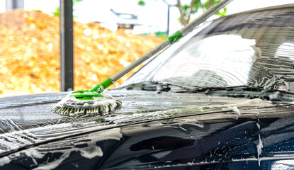 Car wash man using mob and soup cleaning car 