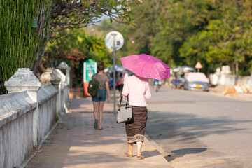 Laotian girl in traditional clothes walks on the street in Luang Prabang. - 644381092
