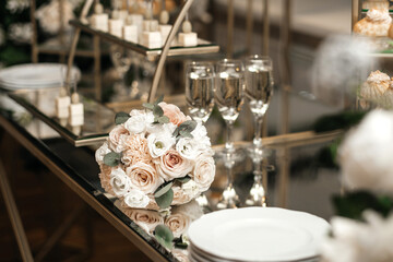 Glasses of champagne. The bride's bouquet. Bottles of wine. An ice bucket. Festive table.
