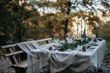 A long, rustic wooden table is placed under a canopy of flowering vines, offering both shade and an enchanting atmosphere