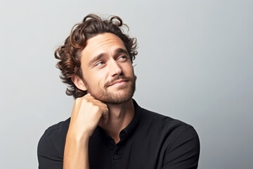 Fototapeta premium Thoughtful dreamy attractive man enjoying calm leisure time at home, looking away in deep thoughts with pensive face, dreaming, thinking over good future plan