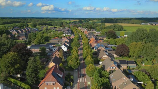 Car drives through avenue of trees in Dutch village in Brabant Gastel drone shot