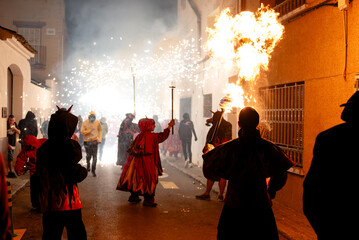 Fototapeta premium Crowd of people on street with devilish costume with fiery display