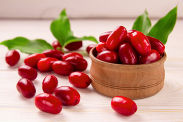 Cornela berries, on a white wooden background. Dogwood berries.