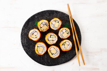 sushi rolls with crab, Japanese omelette and cucumber on a plate.