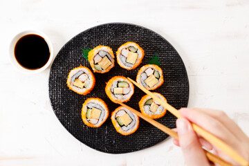 sushi rolls with crab, Japanese omelette and cucumber on a plate.