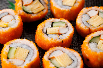 sushi rolls with crab, Japanese omelette and cucumber on a plate.