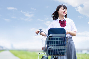 自転車を押して歩く女子高生