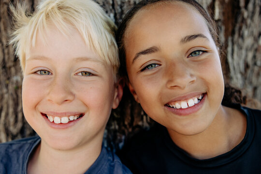 Portrait of smiling blond boy with female friend at summer camp