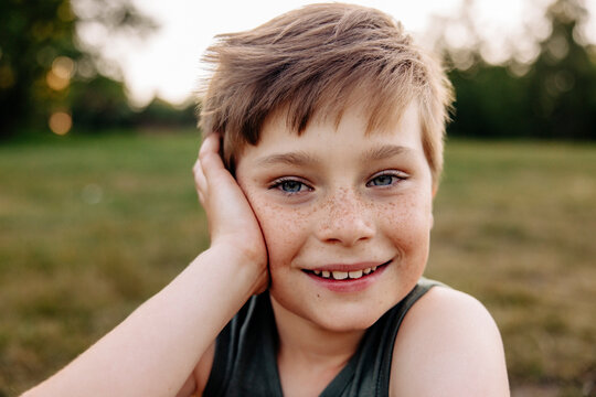 Portrait of happy boy with freckles leaning on elbow