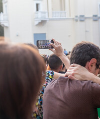 Shot of the woman recording band performance oh her cell phone. Concept